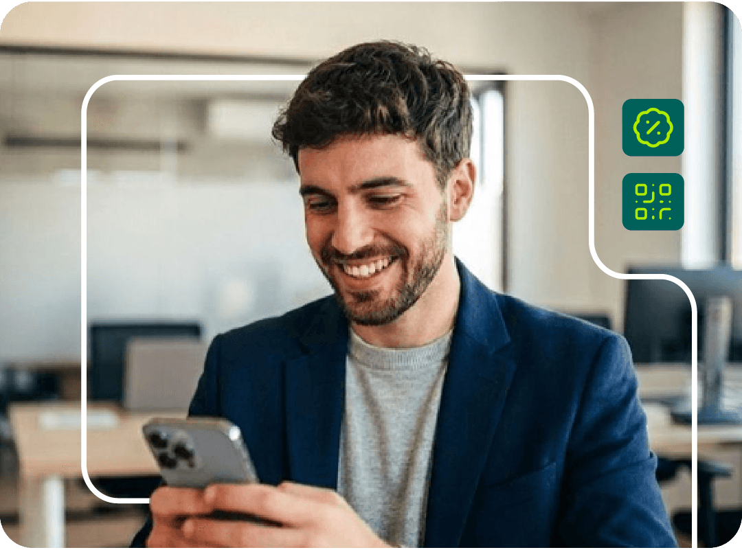 Joven oficinista sonriendo mientras mira su celular.